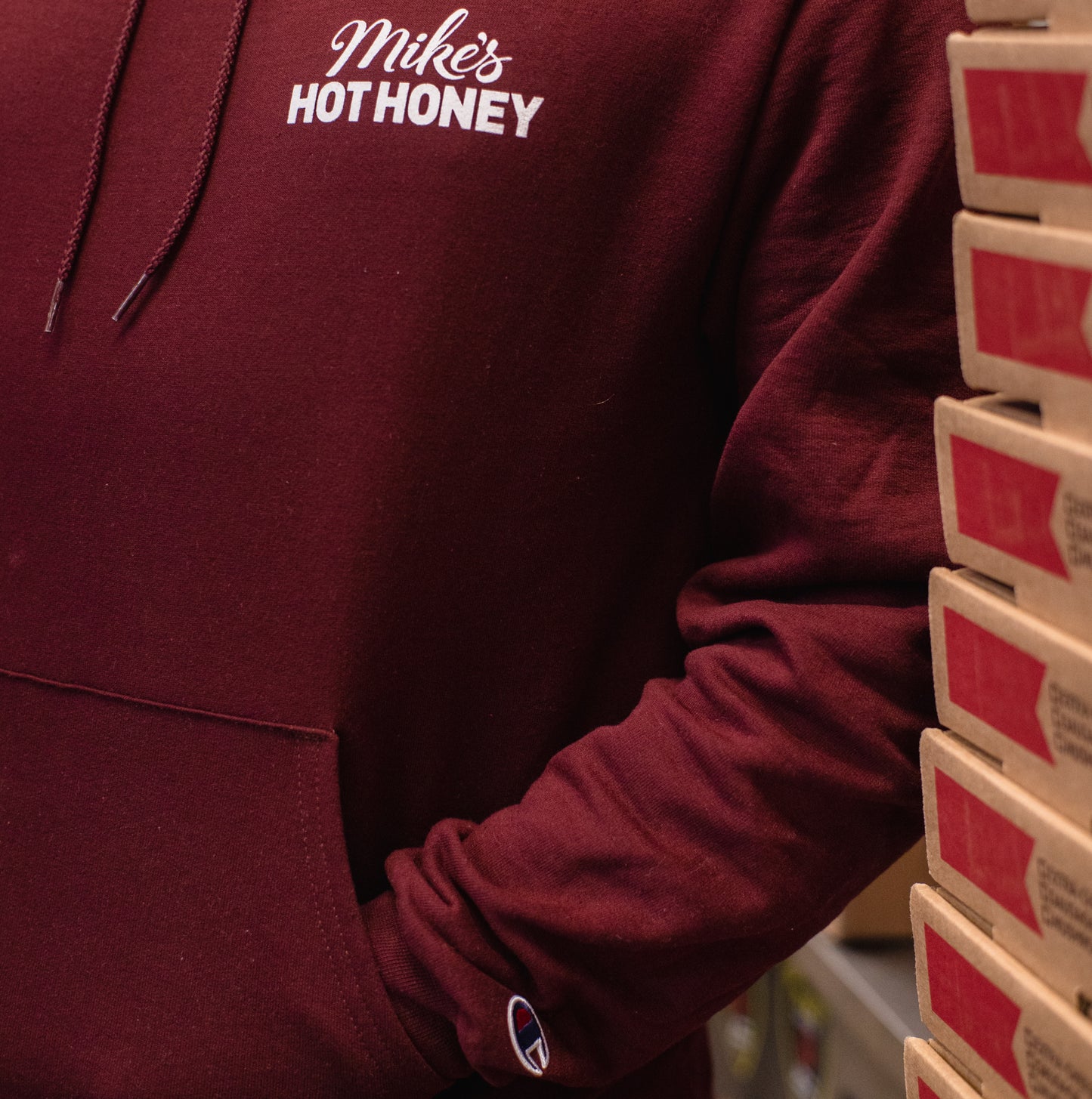 Person wearing Mike's Hot Honey red pullover sweater