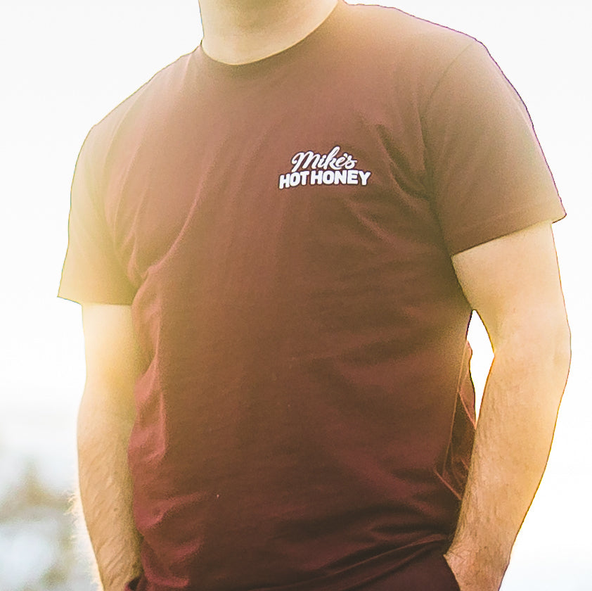 Person wearing Mike's Hot Honey short sleeve burgundy t-shirt